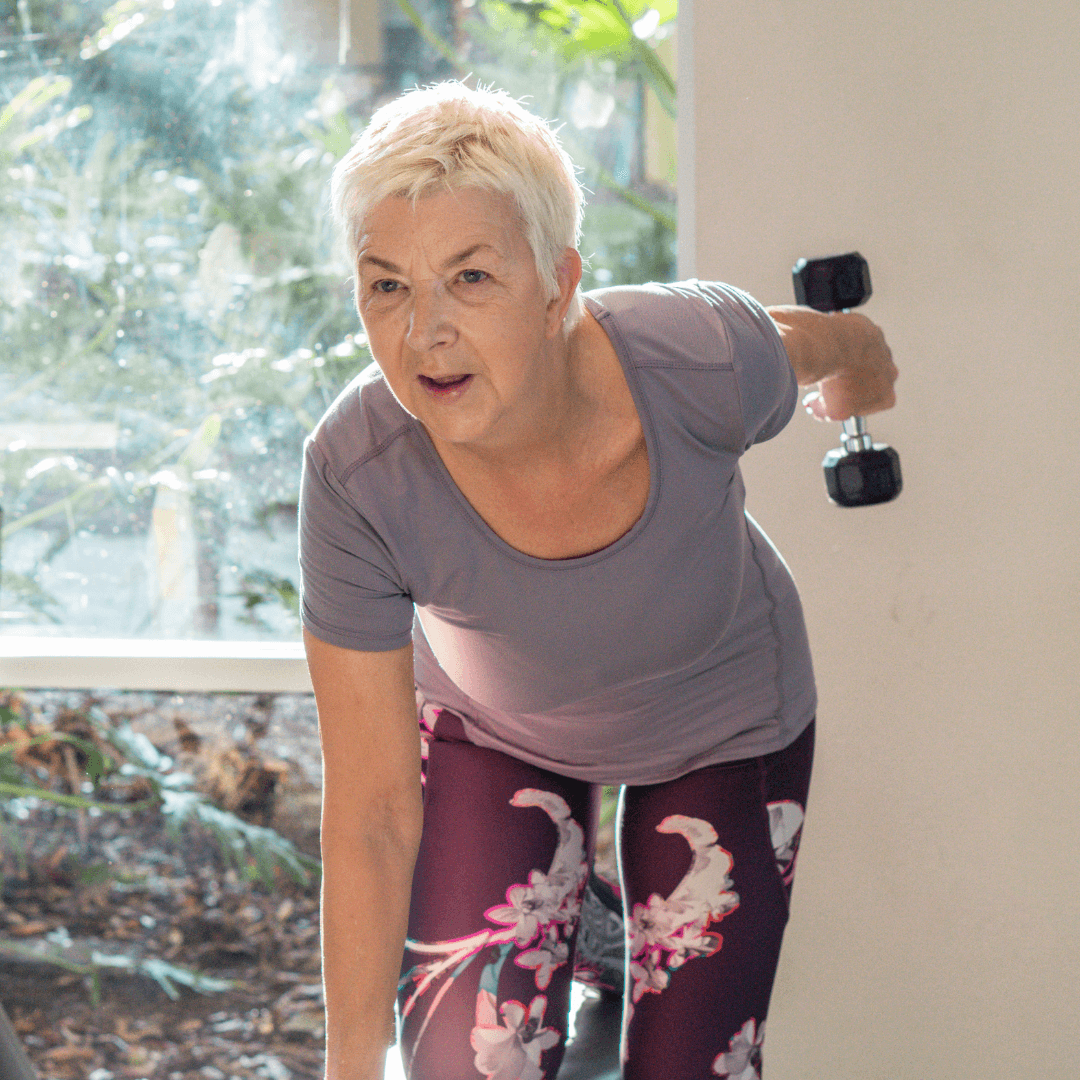 An active older woman confidently lifts weights, demonstrating the benefits of exercise for seniors.