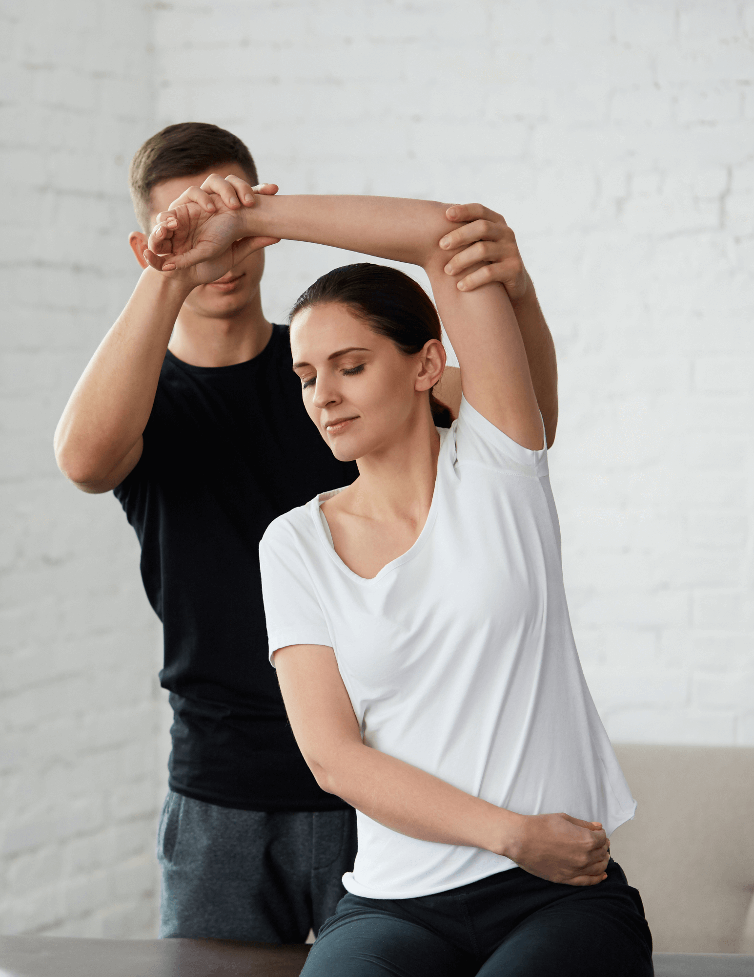 A male recovery specialist assists a woman with a stretching exercise, highlighting XLEVEL's commitment to personalized recovery and injury prevention.